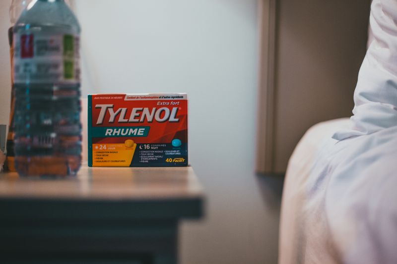 A tylenol bottle on a night time table