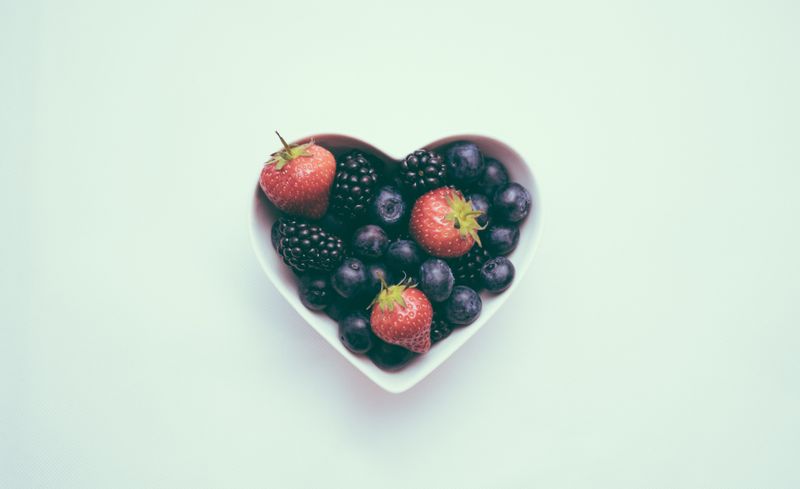 A heart-shaped bowl full of berries