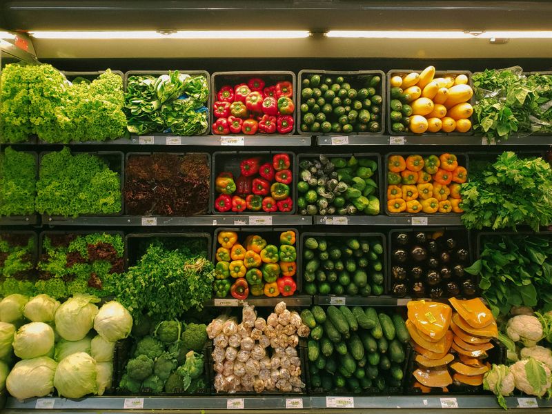 A grocery store aisle filled with different vegetables. 