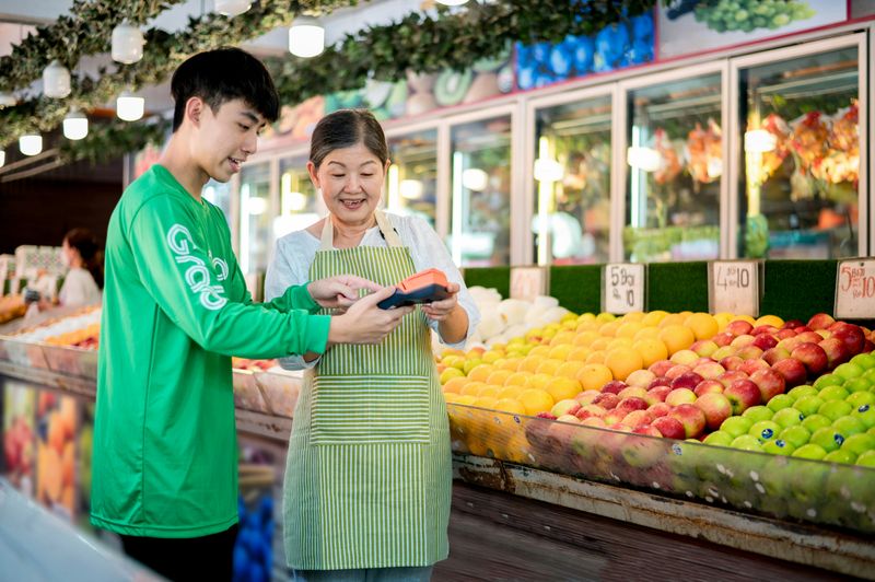 A boy asking an employee for help at a grocery store.