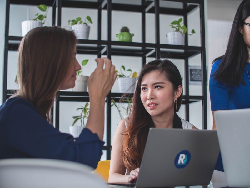 Two women talking at work, and one of them looked upset about what the other is saying