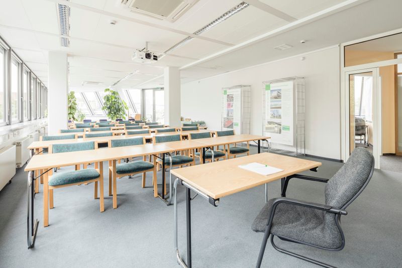 A bright classroom with tables and chairs.