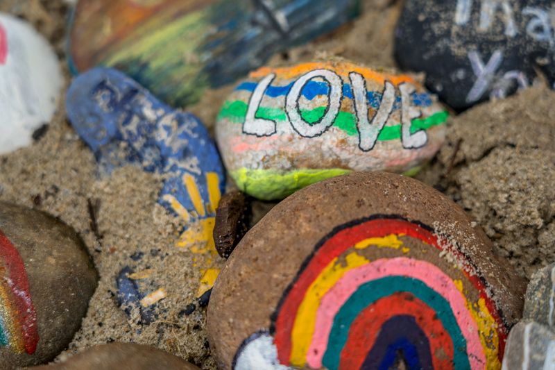Rocks with the word love painted on one and a rainbow on another.