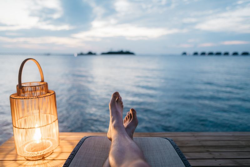 picture of someones feet as they relax on a dock overlooking a lake