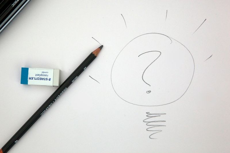 A sketch drawn in pencil of a question mark inside a flashing lightbulb.