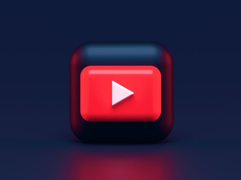 A 3D photo rendering of video symbol in red, blue and white tones against a navy blue background