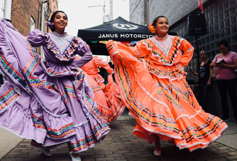 Two young girls displaying their cultural heritage outdoors.