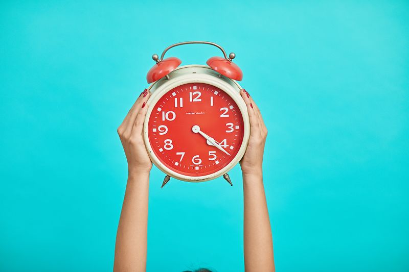  Person holding an analog clock.