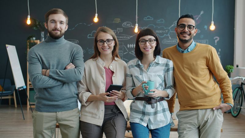 A diverse group of young professionals in an open concept office.
