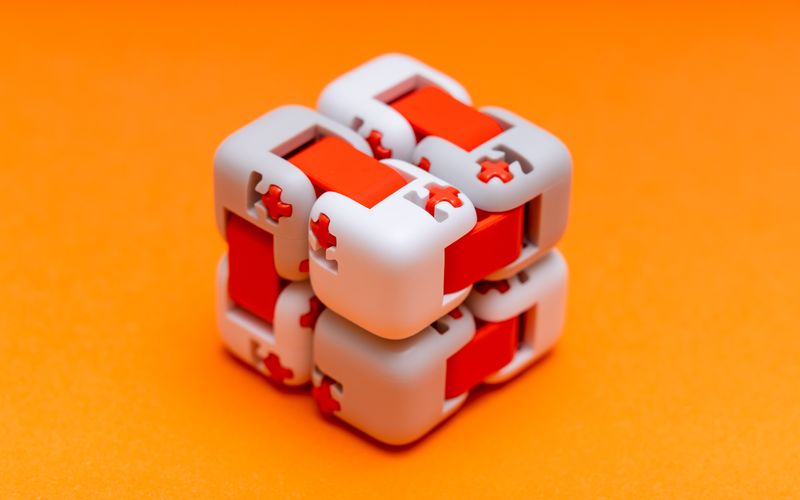 Image: Grey and red-orange focus cube for fidgeting