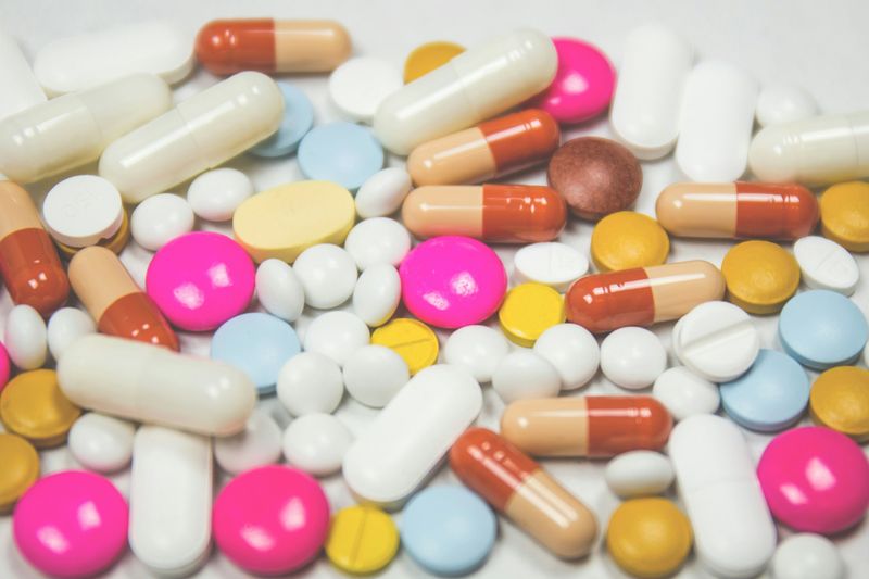 A scattered pile of different pills on a table.