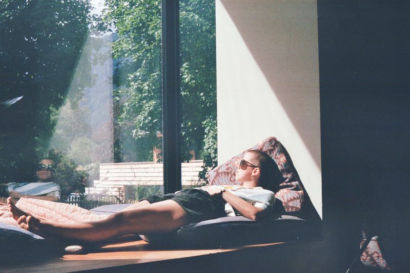 Person relaxing by the window in the sun