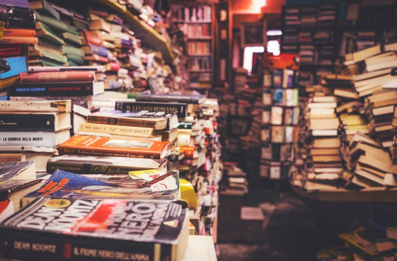 A bookstore full of piles of books.