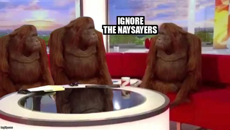 A group of orangutans sit around a table complaining. The text reads: 'Ignore the naysayers'.