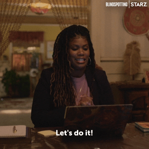A woman saying, 'Let's do it!' in front of her laptop.