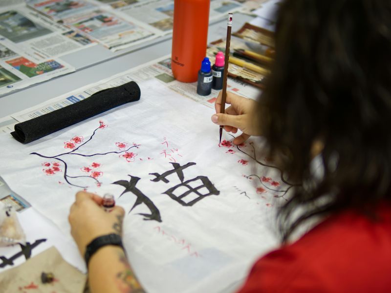 A person practicing kanji calligraphy.