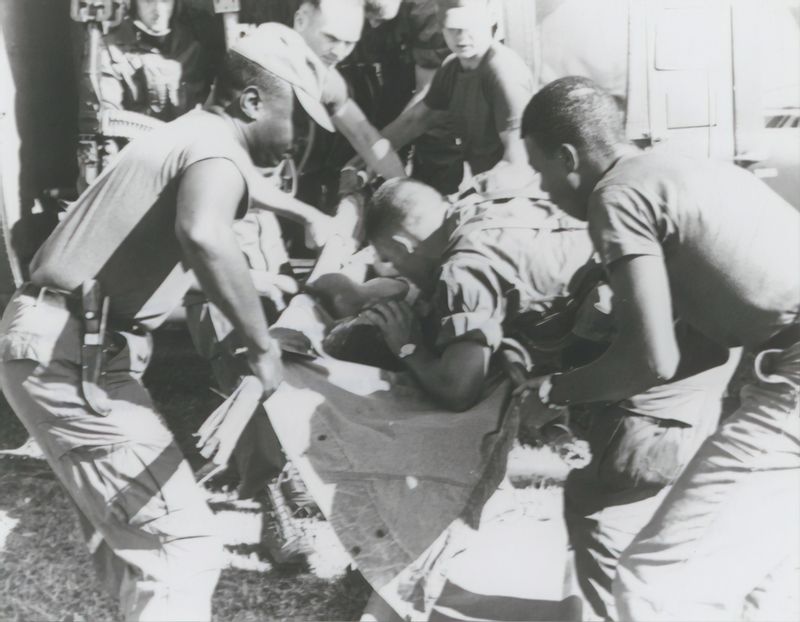 A group of Black soldiers in Vietnam tending to a wounded comrade