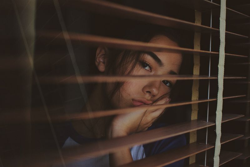 A woman looking through the window and thinking.