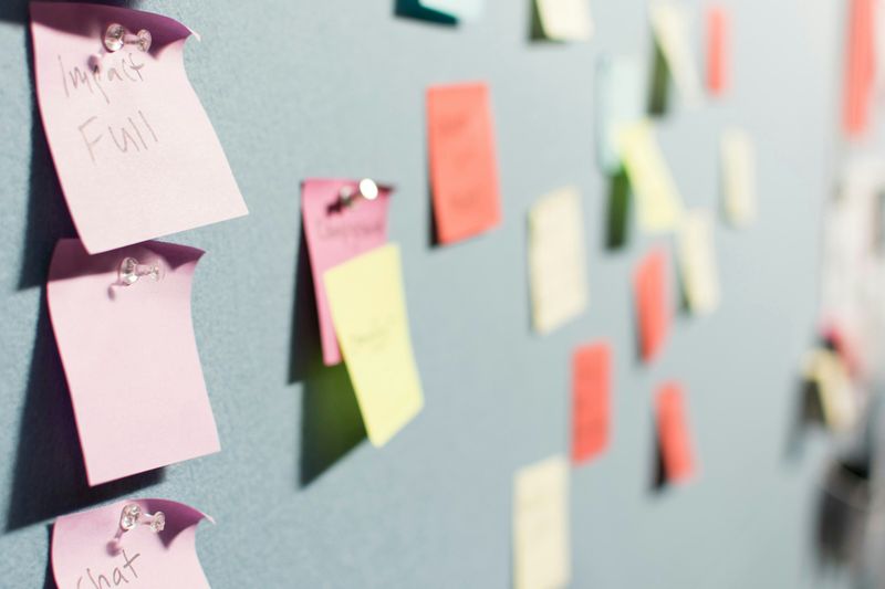 Sticky notes of useful strategies pinned to a board. 