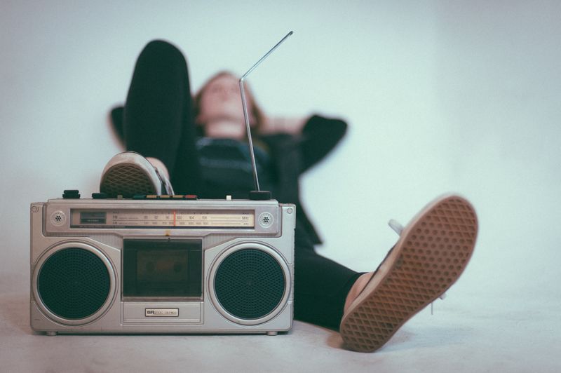A person listening to music in front of a boombox