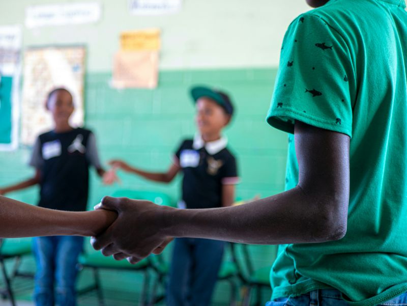 Students hand-in-hand in a circle.