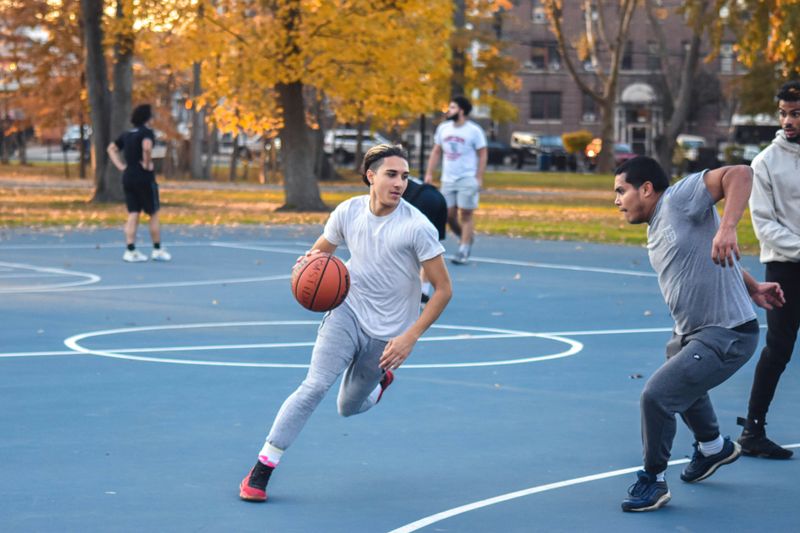 A group of male students playing basketball.