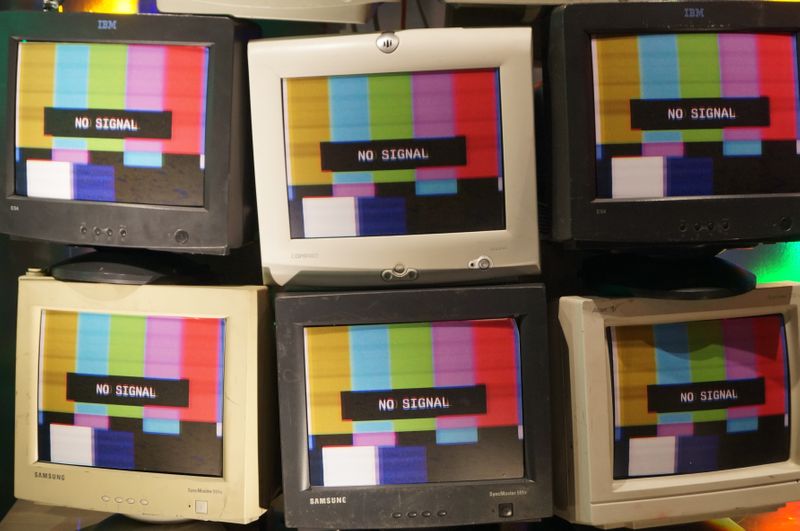 Six small television screens with colored bars on the screen and a message that says 'NO SIGNAL'