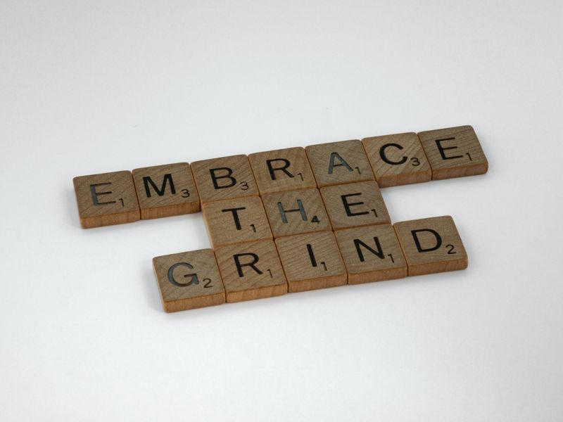 Scrabble tiles that read, "embrace the grind".