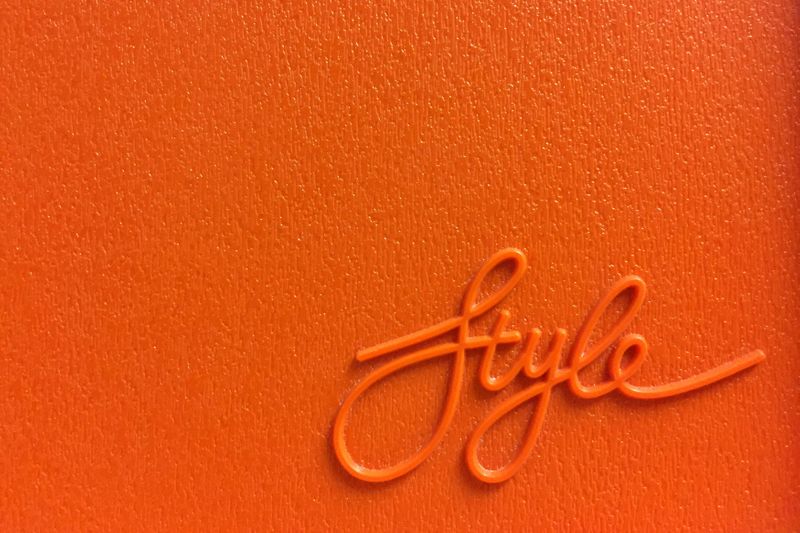 The word 'style' in cursive writing on an orange wall.