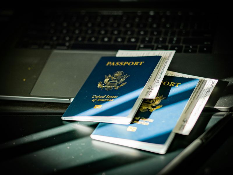 Two U.S. passports on top of a laptop.