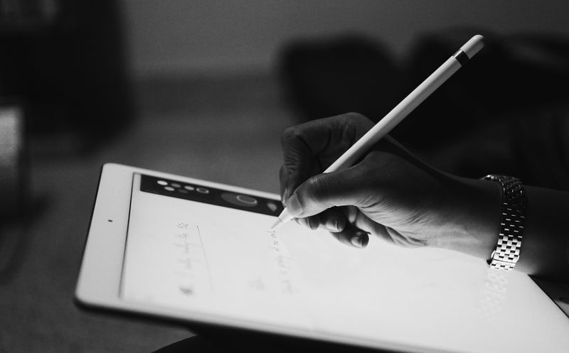 A picture of a person using a pen to take notes on a touchscreen iPad.