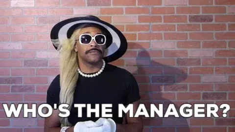 man in a wig and funeral outfit, asking for the manager
