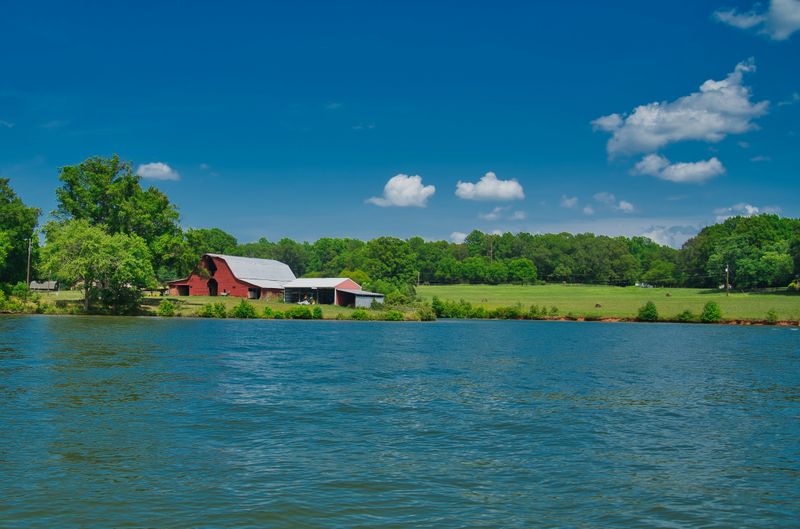 A lakeside farmhouse on a mildly cloudy day.