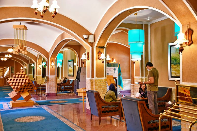 Image of a restaurant with a historical building. A waiter is serving food for guests