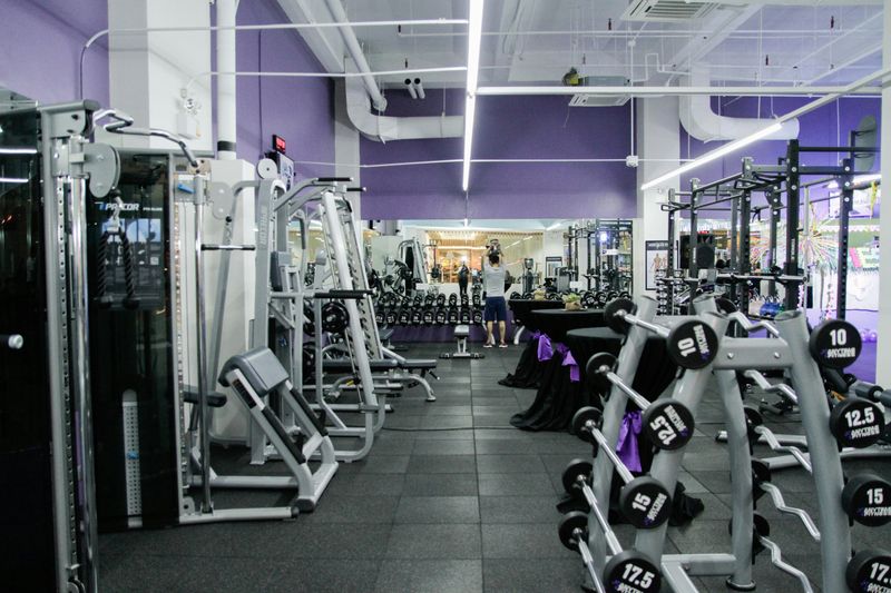 The weight lifting section of a gym with free-weights and machines.