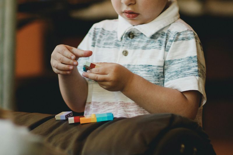 A child playing with Lego building block pieces.