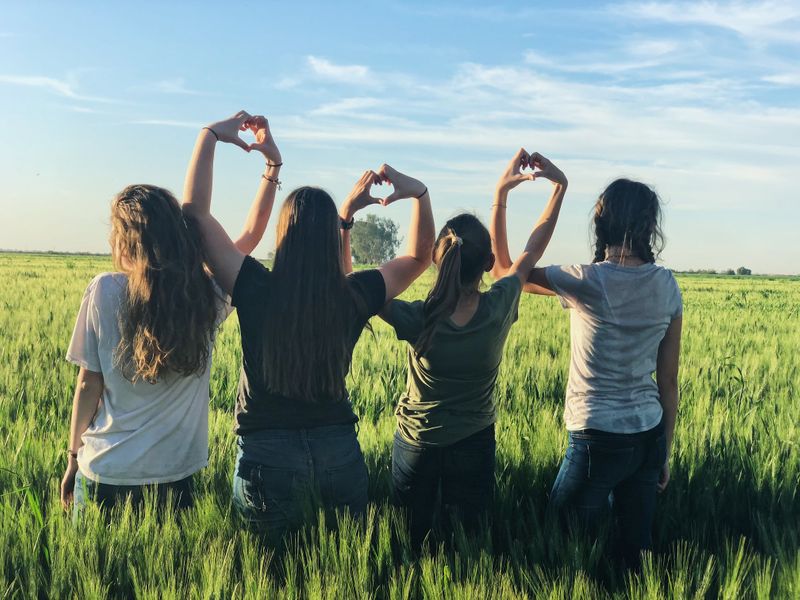 Friends making love signs together. 