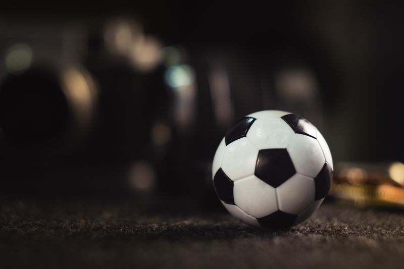 Soccer ball placed to the right of the photo with a dark blurred background. 