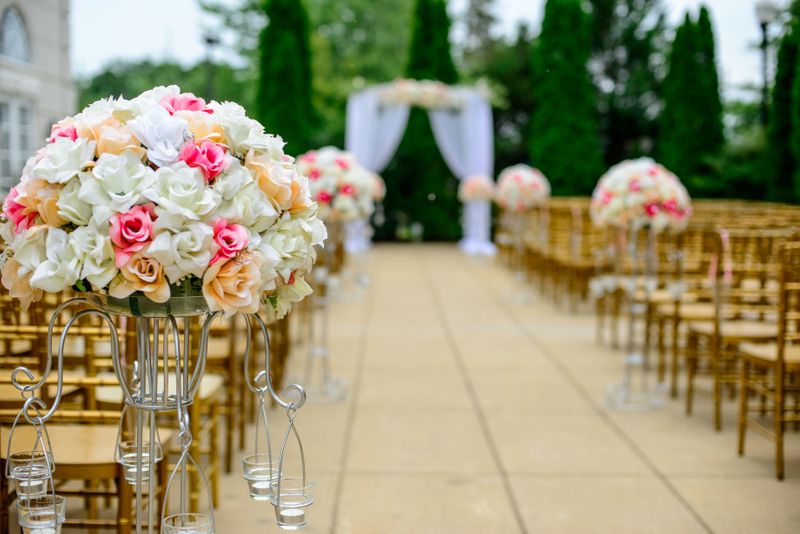 A wedding aisle with flowers and empty chairs before the ceremony.