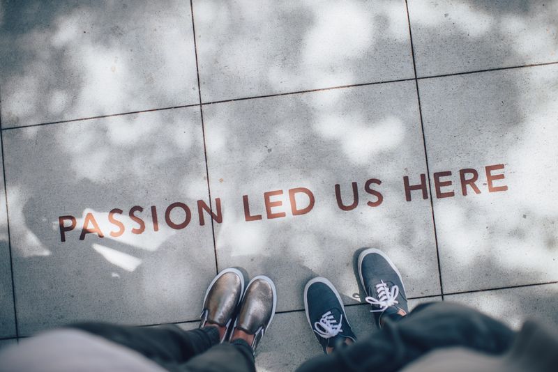 Two pairs of shoes standing on concrete with words 