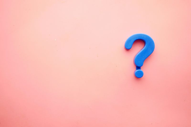 A blue question mark on a peach-colored background.