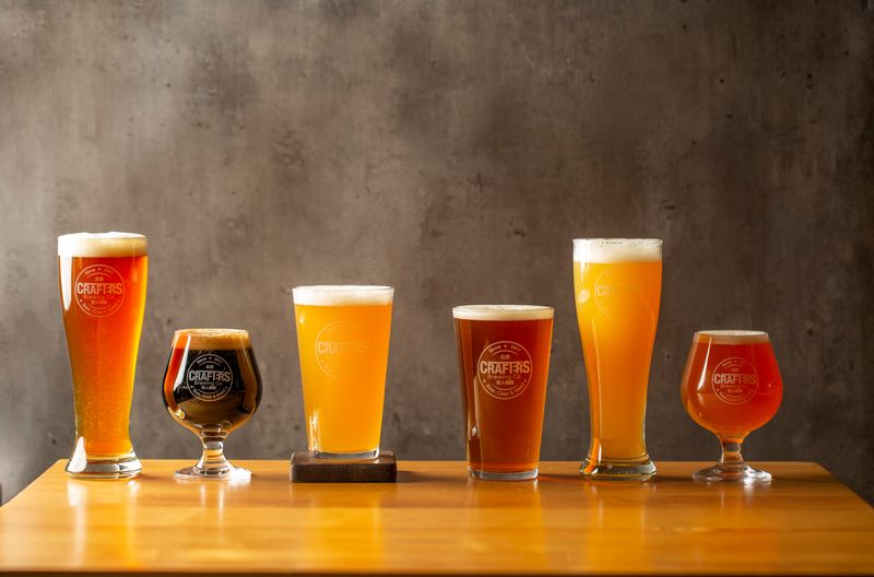 A row of different types of beer, including pale ale, stout, lager, ale, and pilsner.