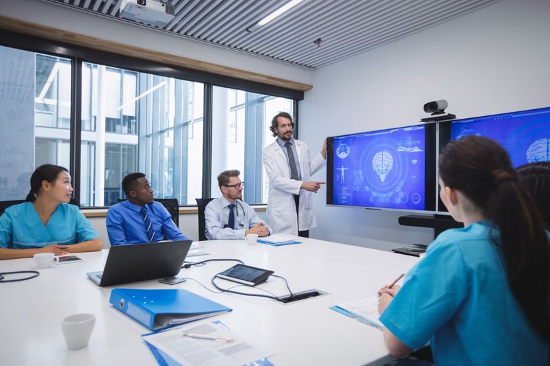 A doctor in a conference room presents medical technology healthcare administrators.