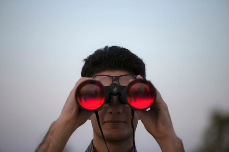 A person looking into binoculars.