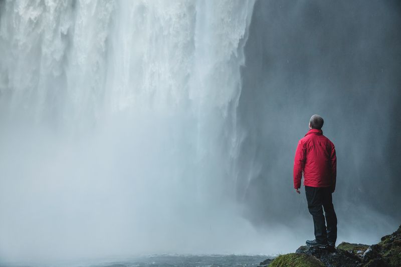 A person looking at a waterfall.