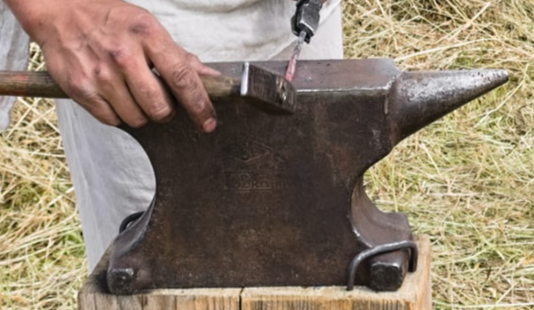 Person using an anvil for shaping metal