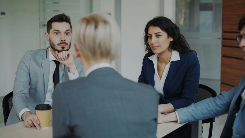 A group of coworkers at a meeting. They respond to ethnocentrism with surprised looks.