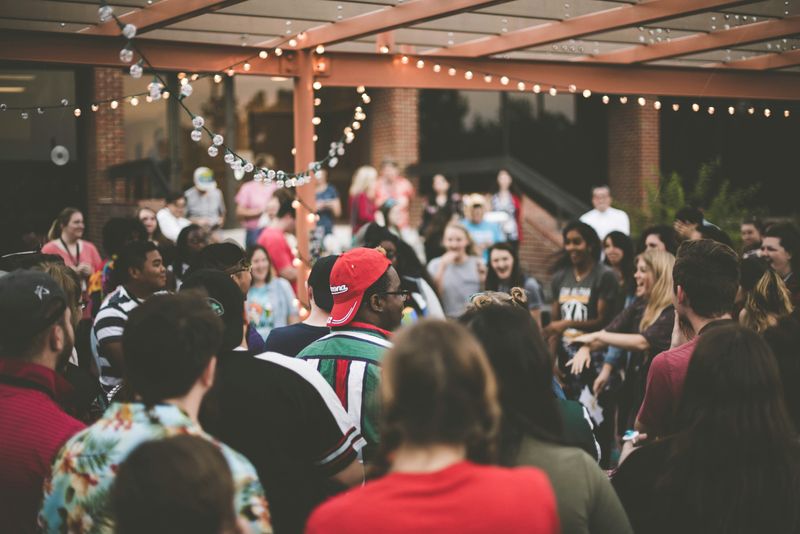 A group of young adults meeting each other during an activity at an event.