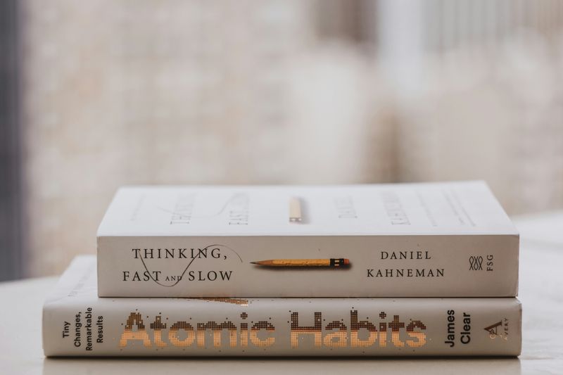Book stacks titled, Thinking, Fast and Slow and Atomic Habits