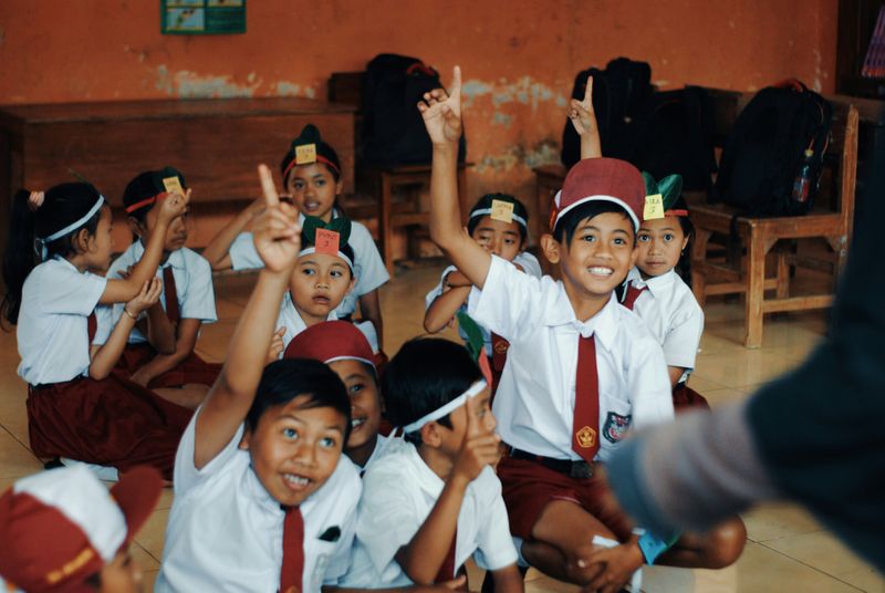 Excited happy children raising their hands.